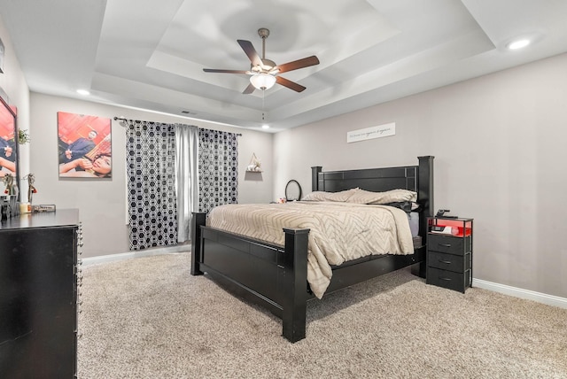 bedroom with carpet floors, a tray ceiling, recessed lighting, and baseboards