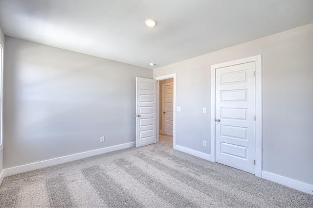 unfurnished room featuring carpet floors and baseboards