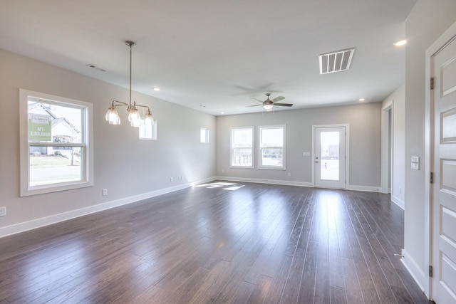 unfurnished living room with visible vents, dark wood finished floors, baseboards, and ceiling fan with notable chandelier