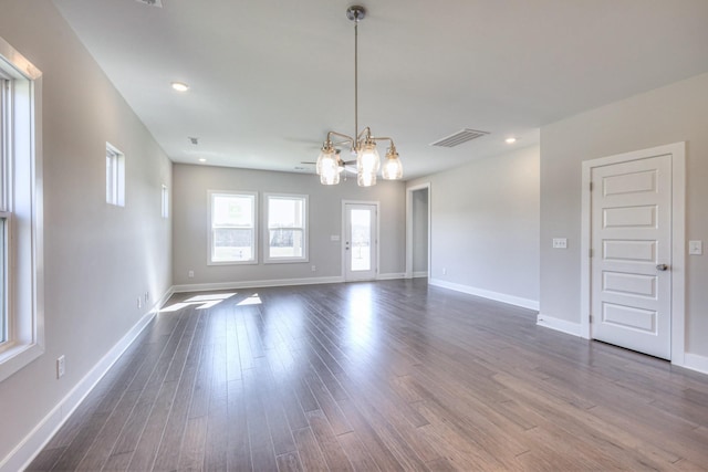 unfurnished room with baseboards, visible vents, dark wood-style flooring, a chandelier, and recessed lighting