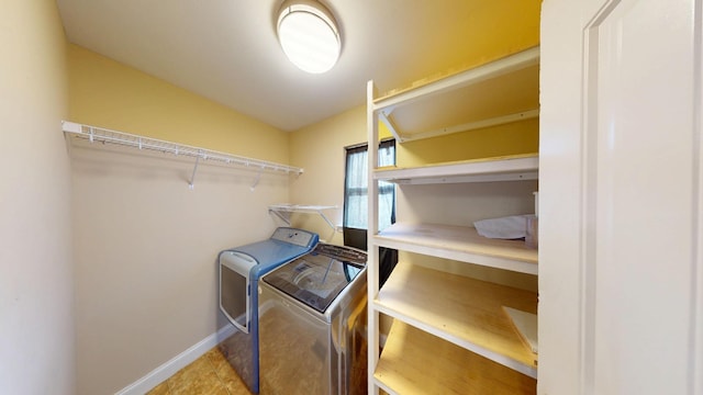 clothes washing area featuring washer and dryer, laundry area, baseboards, and tile patterned floors