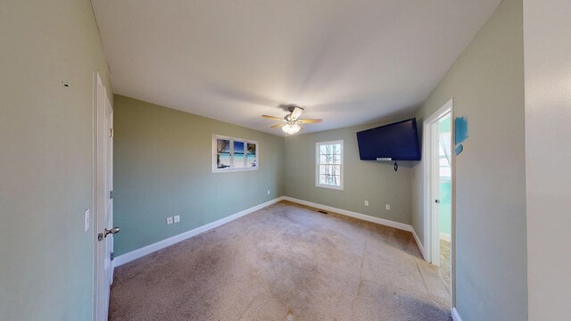 spare room with a ceiling fan, carpet flooring, and baseboards