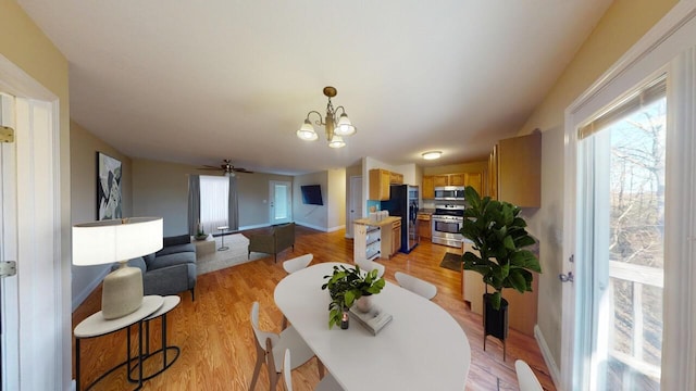 dining room with an inviting chandelier, light wood-style flooring, and baseboards