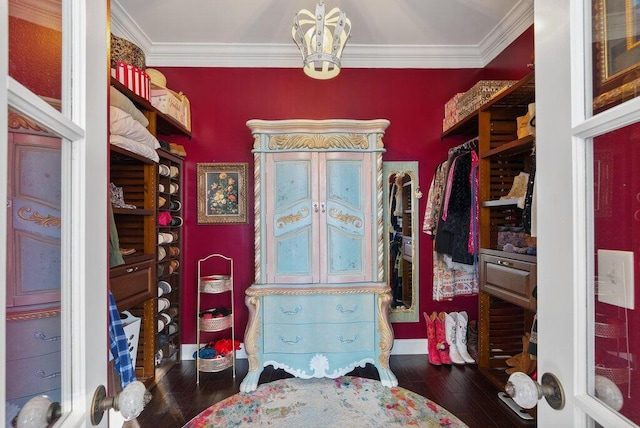 walk in closet with a notable chandelier and hardwood / wood-style flooring