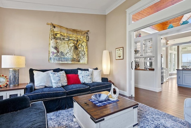 living room featuring hardwood / wood-style flooring, baseboards, and crown molding