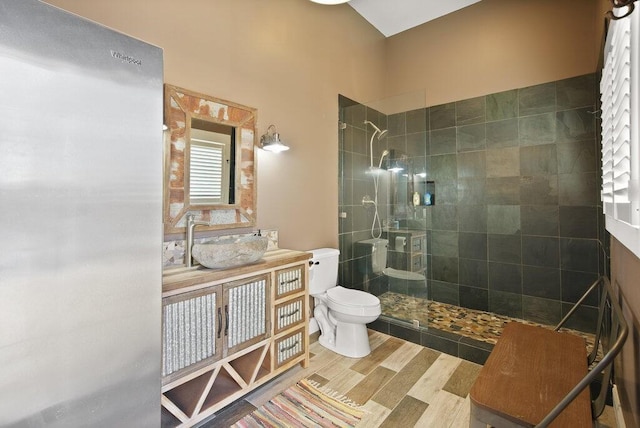bathroom with vanity, wood finished floors, walk in shower, and toilet