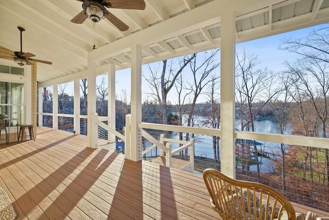 wooden deck with a water view and a ceiling fan