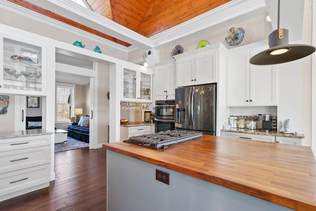 kitchen with double oven, butcher block countertops, white cabinetry, ornamental molding, and stainless steel refrigerator with ice dispenser