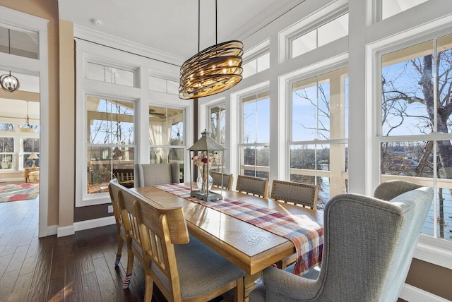 dining area with ornamental molding, dark wood-type flooring, plenty of natural light, and baseboards