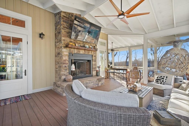 sunroom featuring vaulted ceiling with beams, ceiling fan, and a fireplace