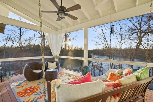 wooden terrace with a water view, an outdoor hangout area, and a ceiling fan
