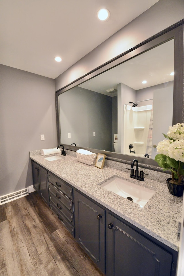 bathroom featuring double vanity, wood finished floors, a sink, and a shower with curtain