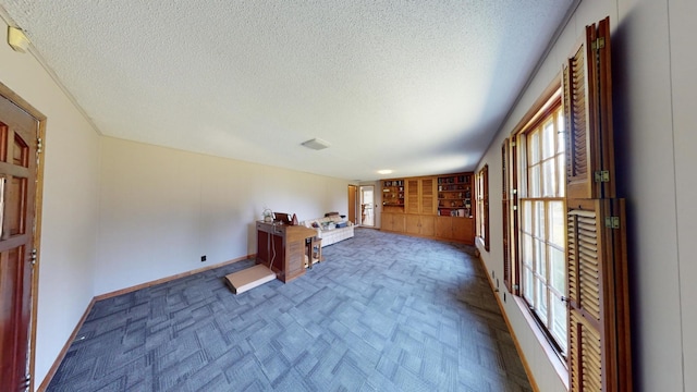 interior space featuring a textured ceiling and baseboards