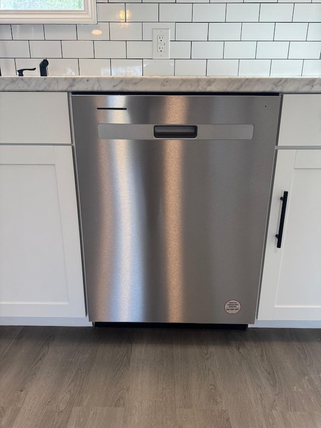 details with light stone countertops, white cabinetry, dark wood-type flooring, and dishwasher