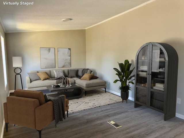 living room featuring visible vents, crown molding, baseboards, and wood finished floors