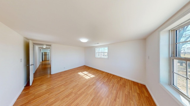 empty room featuring light wood-style flooring and baseboards