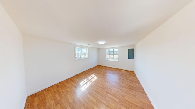 empty room featuring light wood finished floors and baseboards