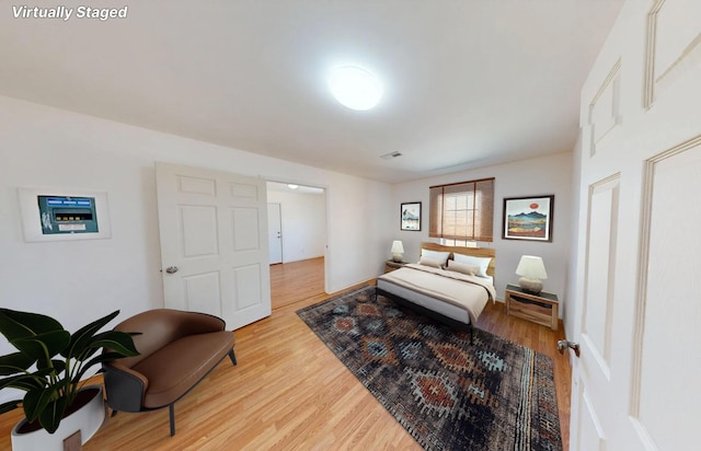 bedroom with light wood-type flooring, visible vents, and baseboards