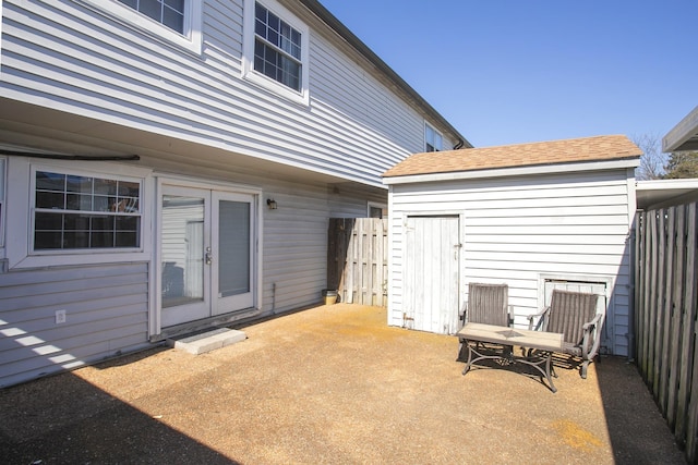 exterior space featuring an outbuilding, french doors, and fence