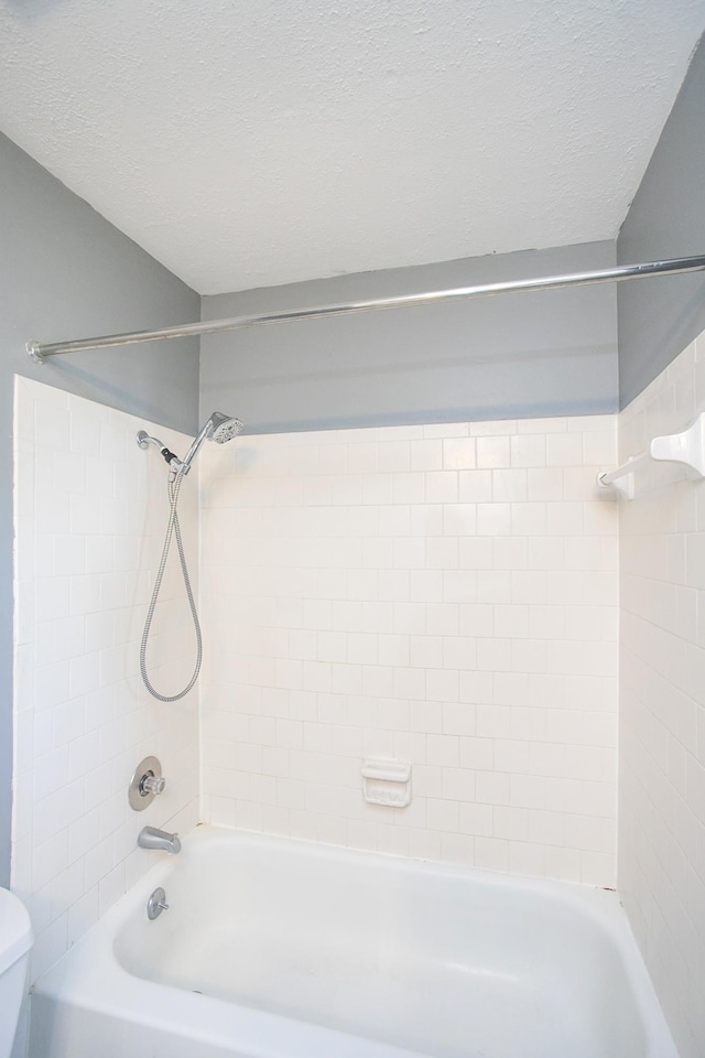 full bath with toilet, bathtub / shower combination, and a textured ceiling