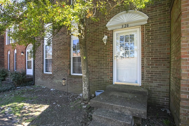 view of exterior entry featuring brick siding