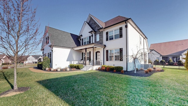 view of front facade with cooling unit, stucco siding, a front lawn, and fence