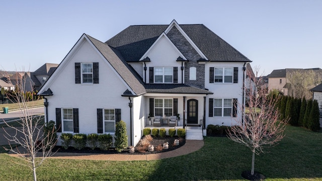 view of front of property with brick siding, covered porch, and a front yard