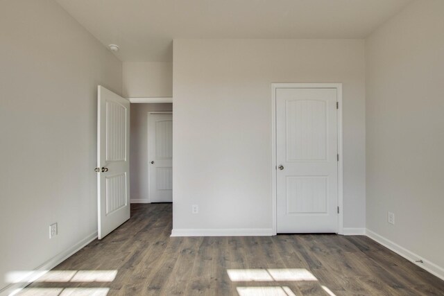 unfurnished bedroom with wood finished floors and baseboards