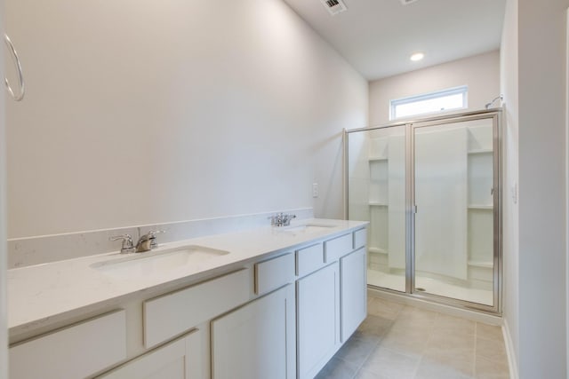 bathroom featuring a stall shower, tile patterned flooring, a sink, and visible vents