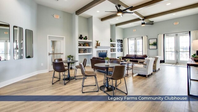 dining space with french doors, a fireplace, beamed ceiling, and wood finished floors