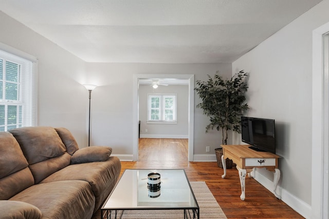 living area with baseboards and wood finished floors