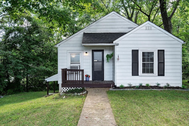 bungalow with a shingled roof, a porch, and a front lawn