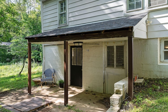 doorway to property featuring a shingled roof