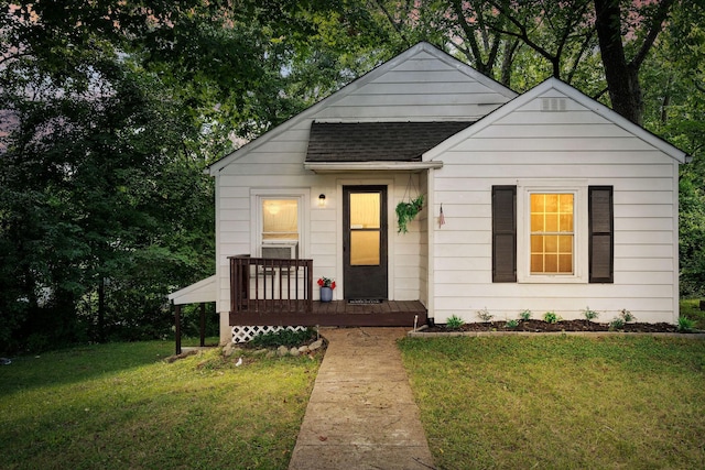 bungalow with roof with shingles and a front lawn