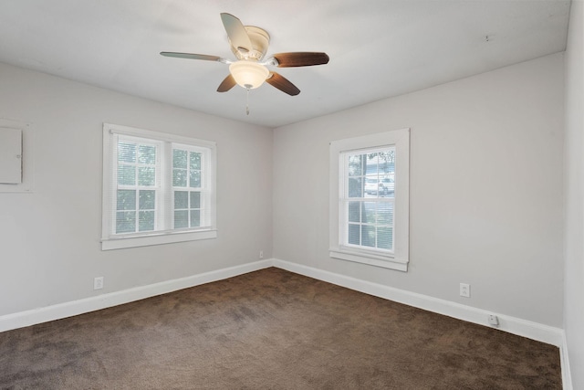 unfurnished room with ceiling fan, baseboards, and dark colored carpet