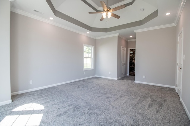 carpeted empty room featuring a tray ceiling, visible vents, ornamental molding, ceiling fan, and baseboards