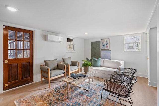 living room featuring light wood finished floors, recessed lighting, baseboards, and a wall mounted AC