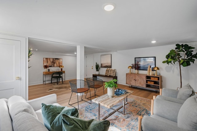 living room with baseboards, wood finished floors, and recessed lighting