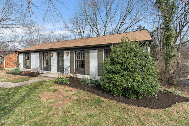 view of front of home with brick siding and a front yard