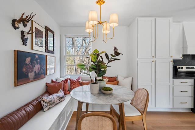 dining room with an inviting chandelier, breakfast area, and wood finished floors