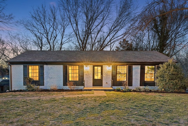 single story home with brick siding and a front lawn