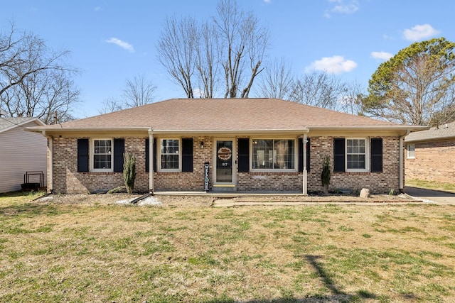 single story home with a shingled roof, a front lawn, and brick siding