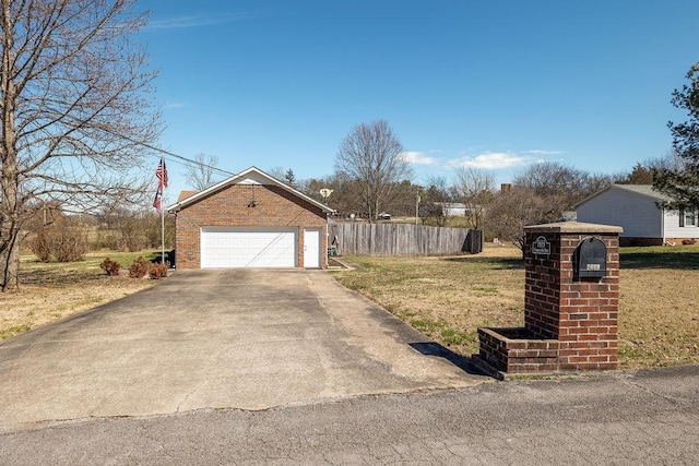 view of front facade with a garage, brick siding, fence, and a front yard