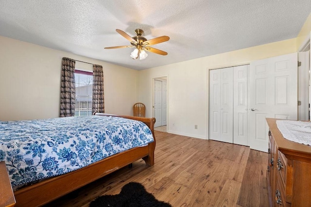 bedroom featuring a closet, ceiling fan, a textured ceiling, wood finished floors, and baseboards