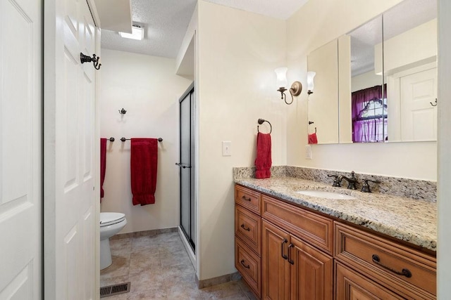 full bath with visible vents, toilet, a stall shower, vanity, and a textured ceiling