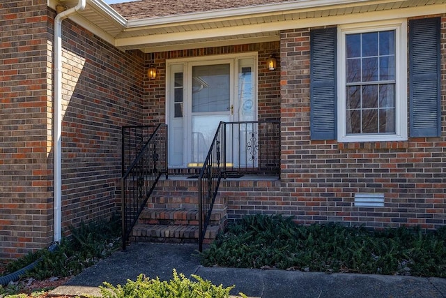 view of exterior entry with brick siding