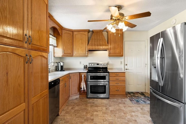 kitchen featuring brown cabinetry, custom exhaust hood, stainless steel appliances, light countertops, and a sink