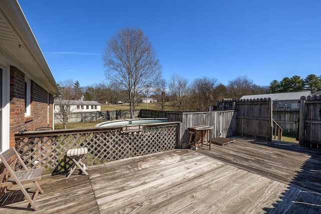 wooden deck featuring a fenced backyard and a jacuzzi