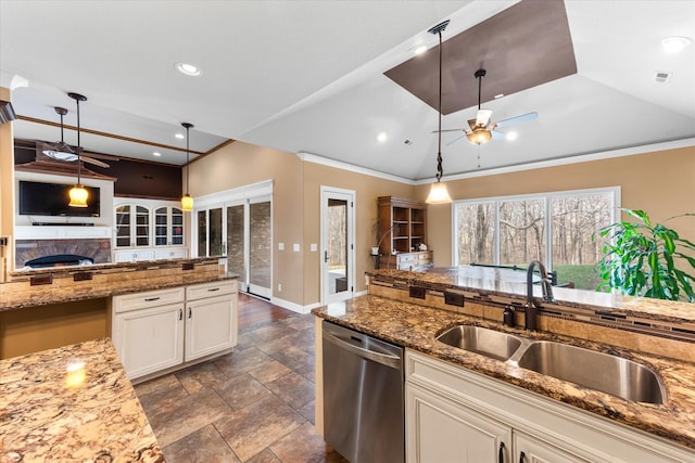 kitchen with lofted ceiling, a sink, a stone fireplace, ceiling fan, and dishwasher