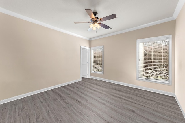 unfurnished room with a ceiling fan, baseboards, crown molding, and wood finished floors